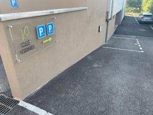 een parkeerplaats met een bord aan de zijkant van een gebouw bij La Clé des vignes 2 in Ribeauvillé