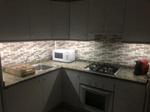 a kitchen with a sink and a microwave at Paraíso in Cumbre del Sol