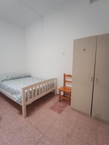 a bedroom with a bed and a cabinet and a chair at Hostel Rural David Broncano in Orcera