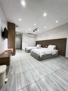 a bedroom with two beds and a television in it at Pyramid hotel in Cairo