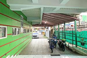 two motorcycles parked next to a building with a car at Hotel O Surya HotelNearTaman Anggrek Pkk Watansoppeng in Watansopeng +29 photos
