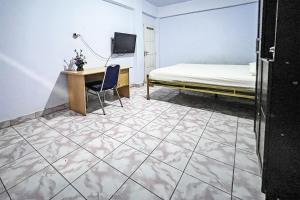 a bedroom with a bed and a desk and a desk at Hotel O Surya HotelNearTaman Anggrek Pkk Watansoppeng in Watansopeng