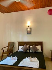 une chambre avec un lit avec deux serviettes dessus dans l'établissement Costa's Villa, Tropical Oasis, Sigiriya Room, à Kepungoda