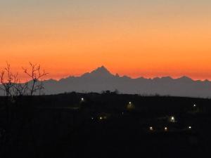 un tramonto con una montagna sullo sfondo di Poderi S Luca ad Alba