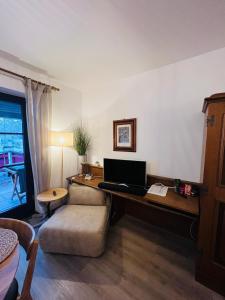 a living room with a desk with a computer on it at Fewo mit toller Dachterrasse & Bademantelgang zur Wohlfühltherme im neuen Stil in Bad Griesbach