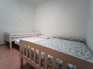 a bedroom with two bunk beds and a crib at Hostel Rural David Broncano in Orcera