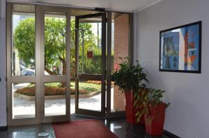 una entrada a un edificio con puertas y plantas de cristal en Residence Le Corti, en Milán