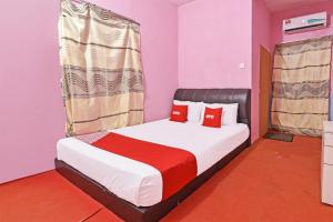 a bedroom with a large bed with red pillows at Capital O 90664 Rabi Hotel in Kota Bharu
