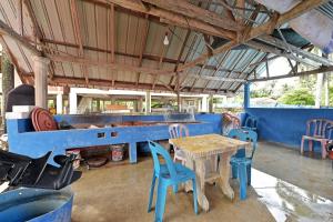 a blue room with a table and chairs at Capital O 90664 Rabi Hotel in Kota Bharu