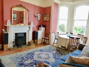 a living room with a table and a fireplace at Downhill Beachhouse Group Accommodation in Castlerock +45 photos