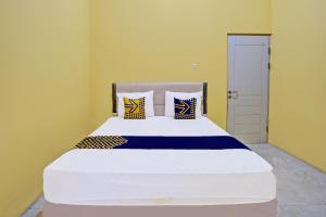 a bedroom with a large white bed with pillows at Hotel O Raffa Residence Syariah in Medokanayu