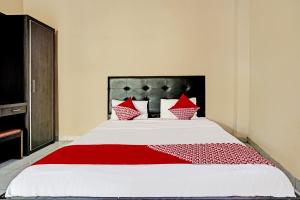 a bedroom with a large bed with red pillows at OYO Life 91873 Nugraha Kost in Palembang