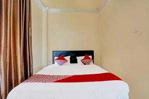 a bedroom with a large bed with red pillows at OYO Life 91873 Nugraha Kost in Palembang