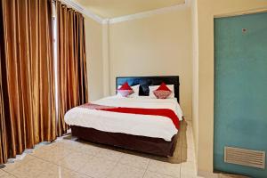 a bedroom with a large bed with red pillows at OYO Life 91873 Nugraha Kost in Palembang +19 photos