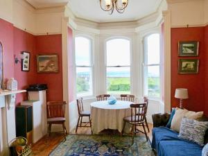 a living room with a table with chairs and a couch at Downhill Beachhouse Group Accommodation in Castlerock