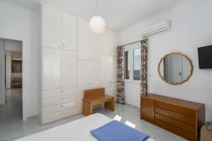 a bedroom with a bed and a mirror and a dresser at Uncle John's House with View in Tripiti