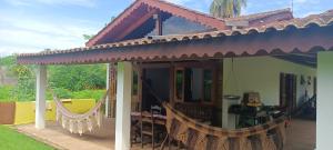 a house with a porch with a hammock outside at Nosso Cantinho Delfinópolis Serra da Canastra in Delfinópolis