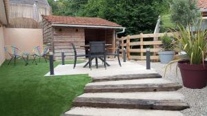 a patio with a table and chairs in a backyard at La Villa des Roses au cœur de Cormoyeux in Cormoyeux