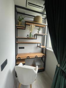 a living room with a white chair and a shelf at Mondden Penthouse in Chişinău
