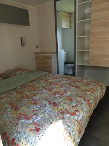 una camera da letto con un letto con una coperta floreale sopra di Mobil Home Grand Confort a Granges-Aumontzey