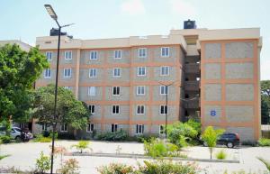 Un edificio con un estacionamiento enfrente. en Kings Sapphire Appartments, en Nakuru