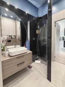 un baño con lavabo y ducha en Hanza Tower - Blue Heaven Apartment - pool, sauna, sunset view, en Szczecin