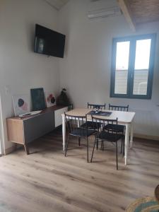 a room with a table and chairs and a bed at La Perlilounette in Le Porge