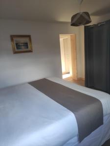 a large white bed in a room with a window at La Perlilounette in Le Porge