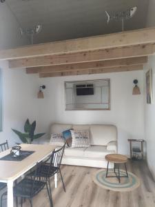a living room with a couch and a table at La Perlilounette in Le Porge