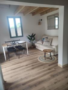 a living room with a couch and a table at La Perlilounette in Le Porge +6 photos