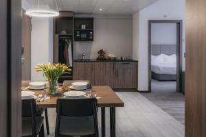 a kitchen and dining room with a table and chairs at IIP Apartments - Self Check-In in Spreitenbach