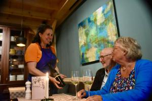 a woman pouring a glass of wine at a table at Studio Kweepeer in Ruinerwold +17 photos