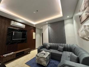 a living room with a couch and a flat screen tv at Al Jawhara Park 1 in Riyadh
