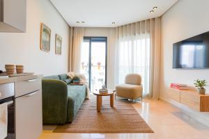 un soggiorno con divano verde e sedia di Appartement Pro et Cosy parfait pour séjour d'affaires a Casablanca