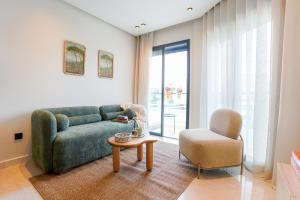 un soggiorno con divano verde e sedia di Appartement Pro et Cosy parfait pour séjour d'affaires a Casablanca
