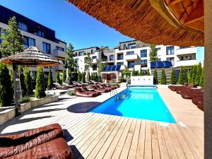 una piscina con sedie a sdraio e un edificio di Premium Loft Apartment a Palanga