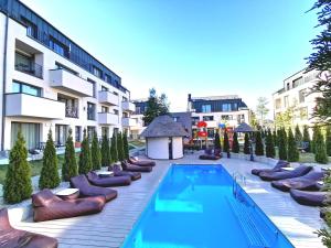 un hotel con piscina e sedie e un edificio di Premium Loft Apartment a Palanga