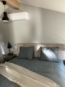 a bed with gray pillows and a white wall at Huisje Emma in Tongeren +16 photos