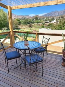 a patio table with chairs and a cactus on a deck at The Galleons in Barrydale