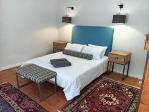 a bedroom with a bed with a blue headboard and a rug at The Galleons in Barrydale