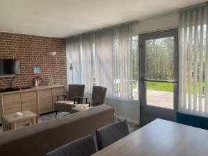 ein Wohnzimmer mit Sofa und Tisch in der Unterkunft Meno Mosso in Sint Maartensvlotbrug