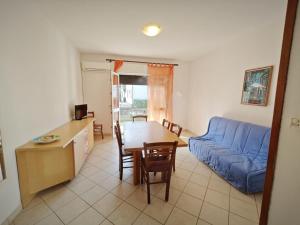 a living room with a blue couch and a table at Berta in Rosolina