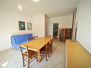 a dining room with a blue couch and a table at Berta in Rosolina