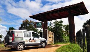 a white van parked next to a sign on a dirt road at Amoras Hotel fazenda in Santo Antônio de Jesus
