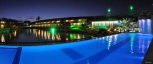 a swimming pool with blue lights in front of a building at Amoras Hotel fazenda in Santo Antônio de Jesus