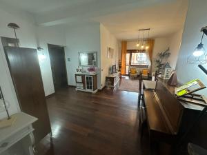 a living room with wooden floors and a living room with a table at La casa di Fred in Rome