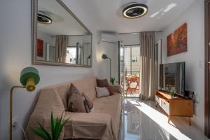 a living room with a couch and a mirror at Central bright home in Heraklion in Bendevís
