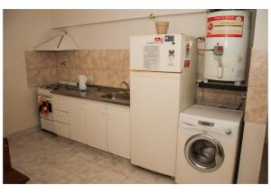 een keuken met een wasmachine en een wastafel bij Hospedaje Los Macaes 2 in Comodoro Rivadavia