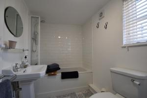 ein weißes Badezimmer mit Waschbecken und Toilette in der Unterkunft Mim's Cottage in Rye + 17 Fotos