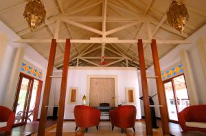 a dining room with a table and red chairs at Kura Kura Resort in Karimunjawa